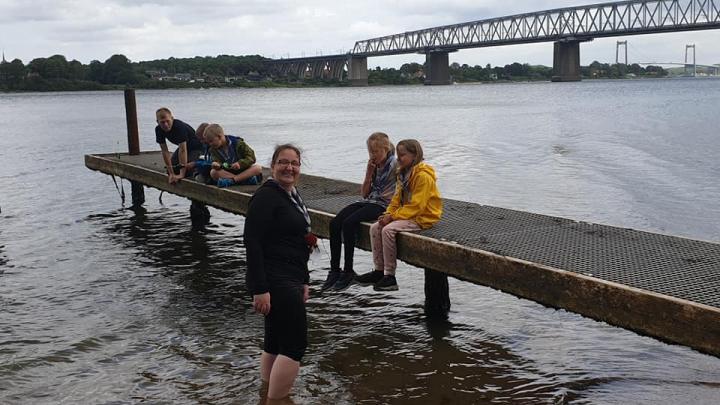 Minispejder der sidder på badebro med begge lillebæltsbroer i baggrunden.